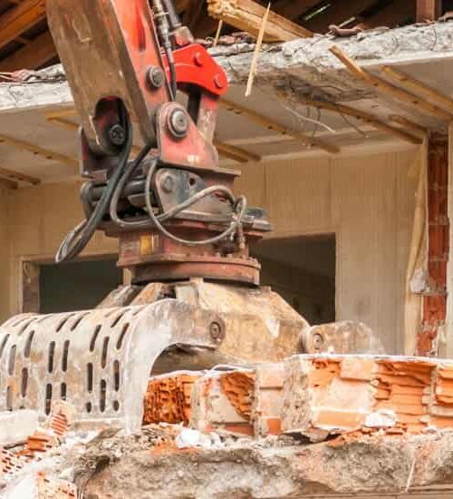 Excavator demolishing a structure in Maine for Rubbish Doctor demolition services